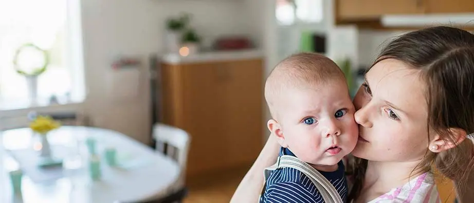 Flicka som står med en plåt bullar